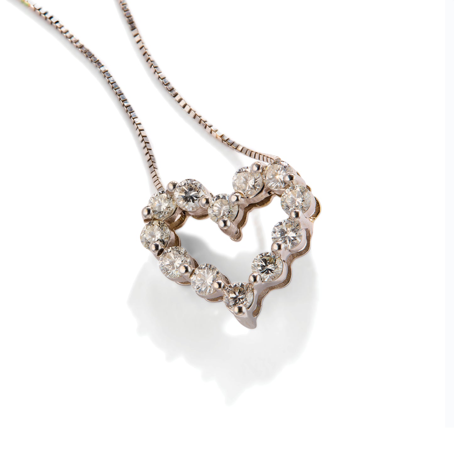 Tarnished heart-shaped diamond pendant on a white background