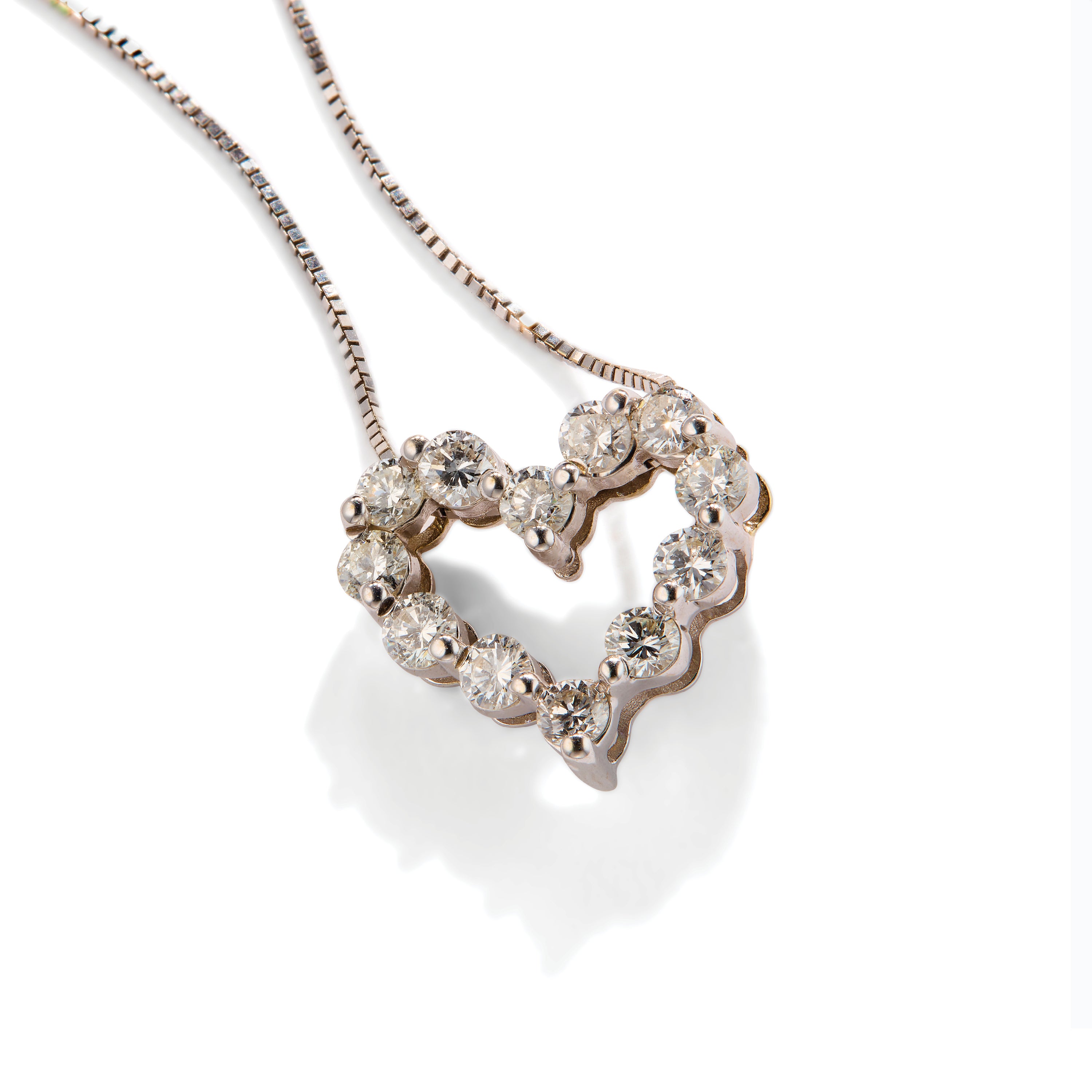 Tarnished heart-shaped diamond pendant on a white background