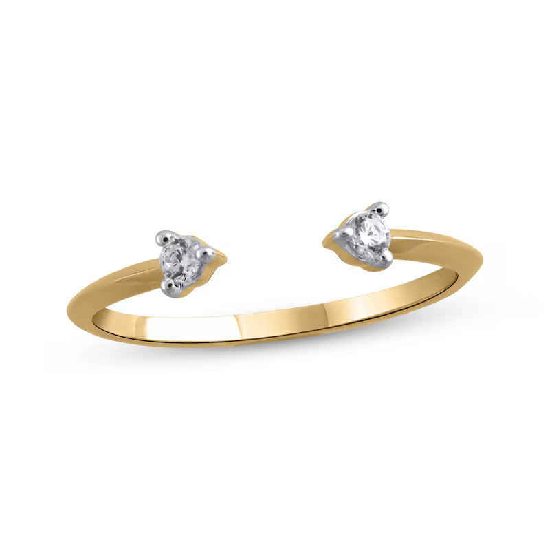 A gold-colored open band ring with two prominent white stones set at the ends.