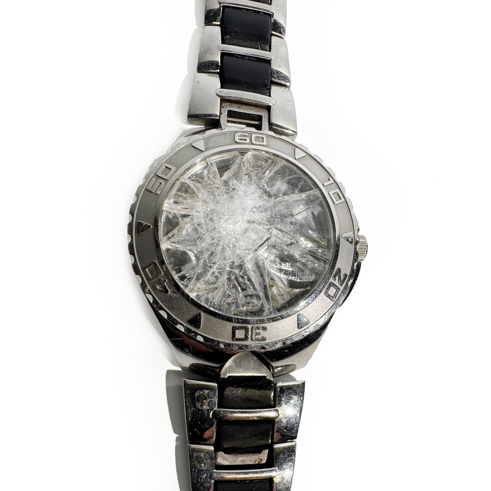 Silver watch with a broken crystal on a white background