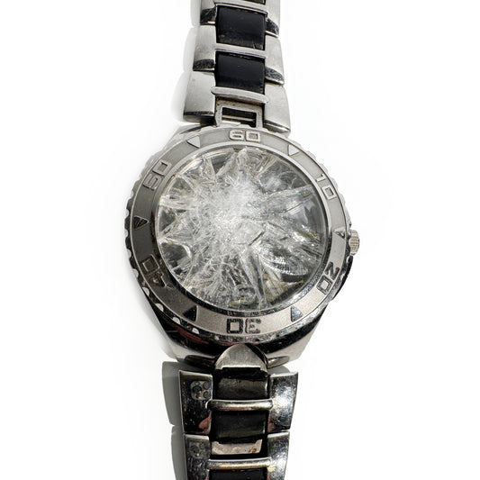 Silver watch with a broken crystal on a white background