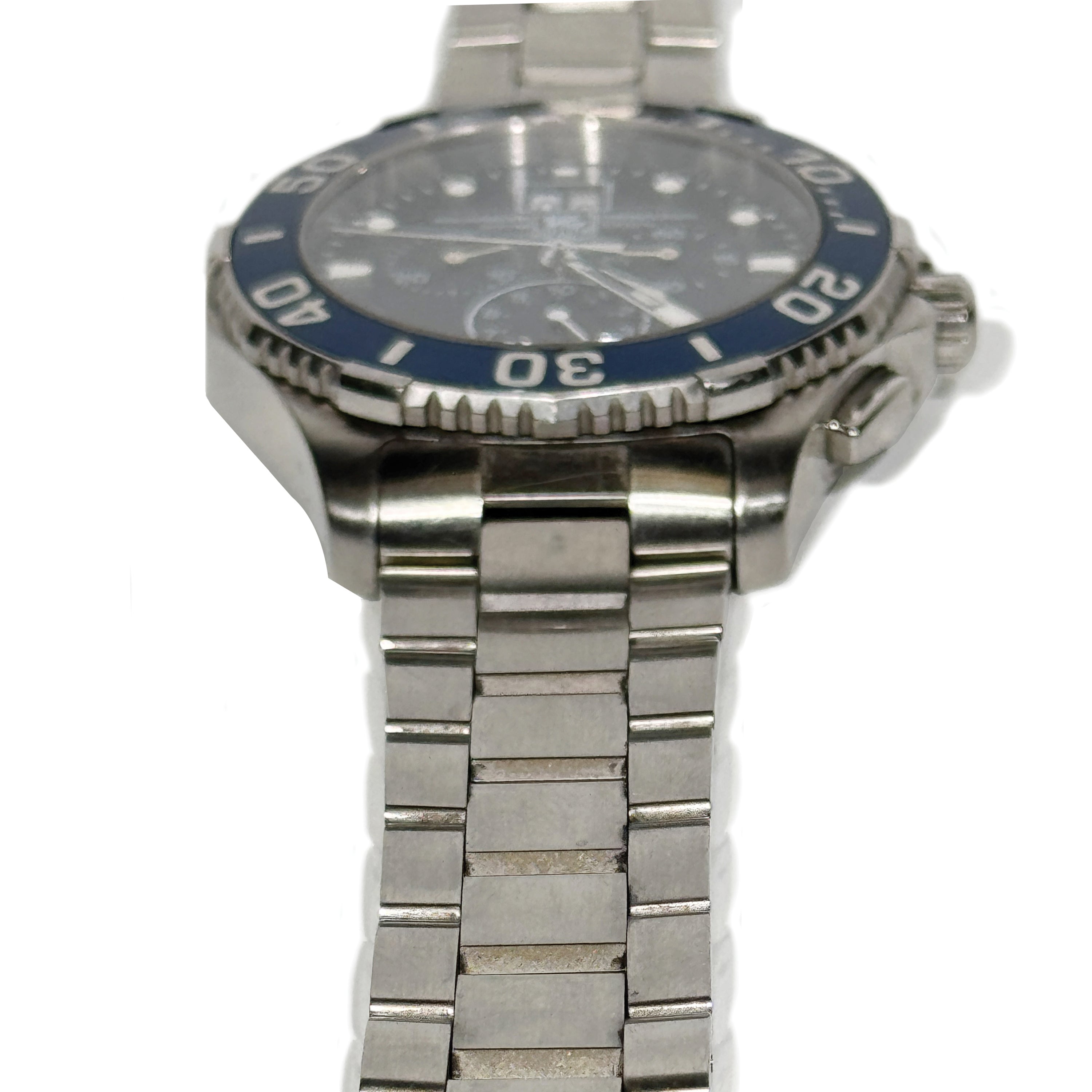 Tarnished and dirty silver watch with a blue bezel on a white background.
